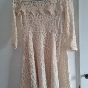 Vit klänning  - Vit/beige klänning med en lång mesh kjol som ingår. Bra kvalite. Används endast 1 gång.  Storlek XS