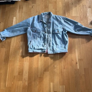 Ljusblå jeansjacka - Skitsnygg, ljusblå jeansjacka med rosa detaljer. Vet inte märket men den är köpt second hand. Skriv gärna om ni har frågor!