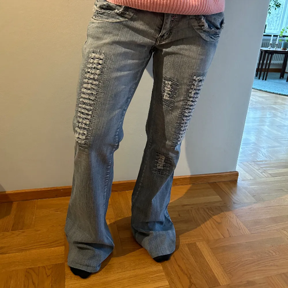 Ett par så coola, unika jeans med slitningar. Lowwaist, bootcut passform. Modellen på bilden är 165, men de är något stora på henne. Midjemåttet är 43 och innerbenslängd 84. Skriv för mer info💕. Jeans & Byxor.