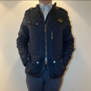 Morris Jacka - Slående i sin mörkblå nyans, denna Morris jacka kombinerar tidlös elegans med modern design. Perfekt för både formella och avslappnade tillfällen. För endast 349kr blir denna jackan din! Nypris ligger på 2995 så det är ett riktigt kap!