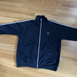 Fred Perry zip-up kofta - St XL, väldigt bra skick, nästan oanvänd, inga fläckar eller märken. Killen på bilden är 189 cm. Snabba möten om du bor i Lund eller Malmö. 