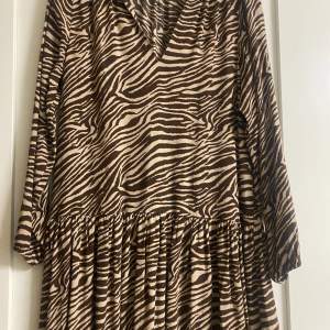 Superfin klänning med brunt zebramönster! Använd ett fåtal gånger!