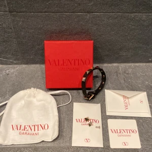 Valentino armband - Säljer mitt svarta valentino armband med guldiga spikar. 9/10 skick. Äkthetsbevis finns. Skriv gärna vid funderingar! 