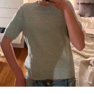 Stickad t-shirt -  Stickat t-shirt från H&M i super gott skick. Är i en superfin grå/blå färgu. Super fin passform!