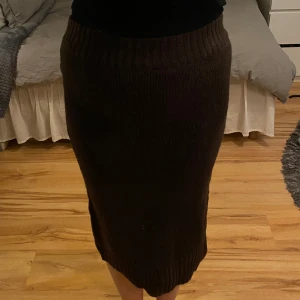 Stickad kjol - Helt oanvänd stickad kjol i mörkbrun färg  från Gina Tricot. 