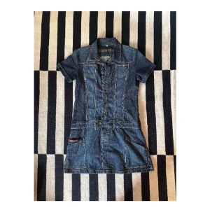 Jeansklänning mini - Jeansklänning i 98% bomull, 2% elastan.  Lite osäker på märket med det står Denim Wear i klänningen. Storlek 38. Jag själv är 176 cm och brukar ha storlek 36 eller 38 och den passar bra på mig. Den är lite åt det over-sized hållet. 