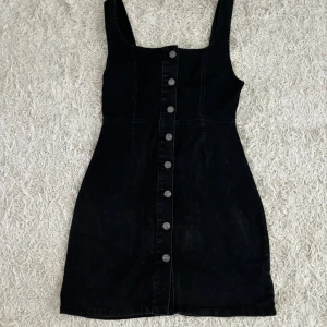 Jeansklänning - Svart jeansklänning med knappar i storlek 36