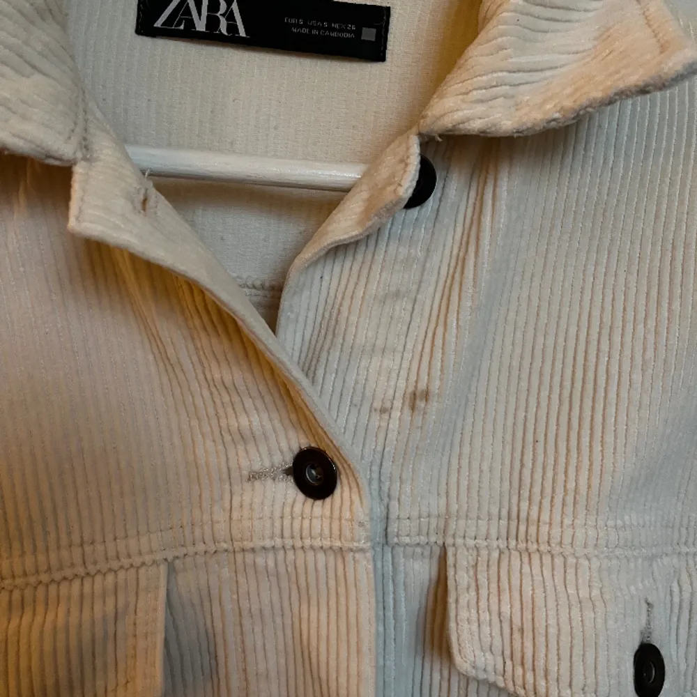 Vit manchesterjacka från Zara i storlek S. Använt skick och har en fläck (se bild 3), där av det billiga priset. Går möjligtvis att få bort.. Jackor.