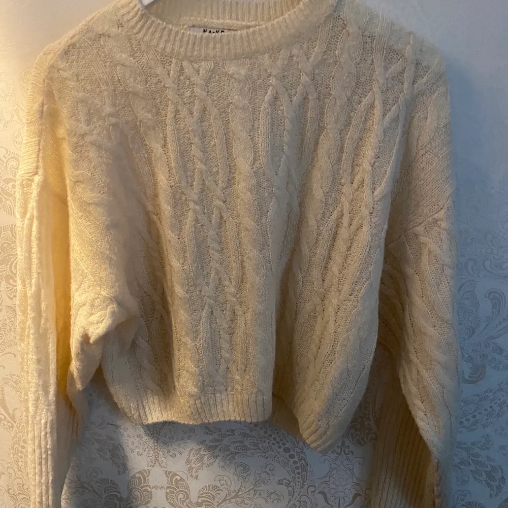 Beige/vit stickad långärmad tröja från NA-KD  med luftigt material. Har mönster detaljer, kommer inte till användning därför säljer jag 🤍🤍. Stickat.
