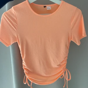 Aprikos/orange topp med snörning  - Säljer denna t-shirt/topp då den inte används. I fint skick och normal i storlek💓