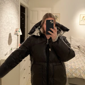 Sandro pufferjacket - Snygg vinterjacka från Sandro! Köpt på Nk för ca 2 år sedan. Funkar att vänta ut och in till en helt silvrig jacka. Perfekta jackan för vintern🖤🦋🦋
