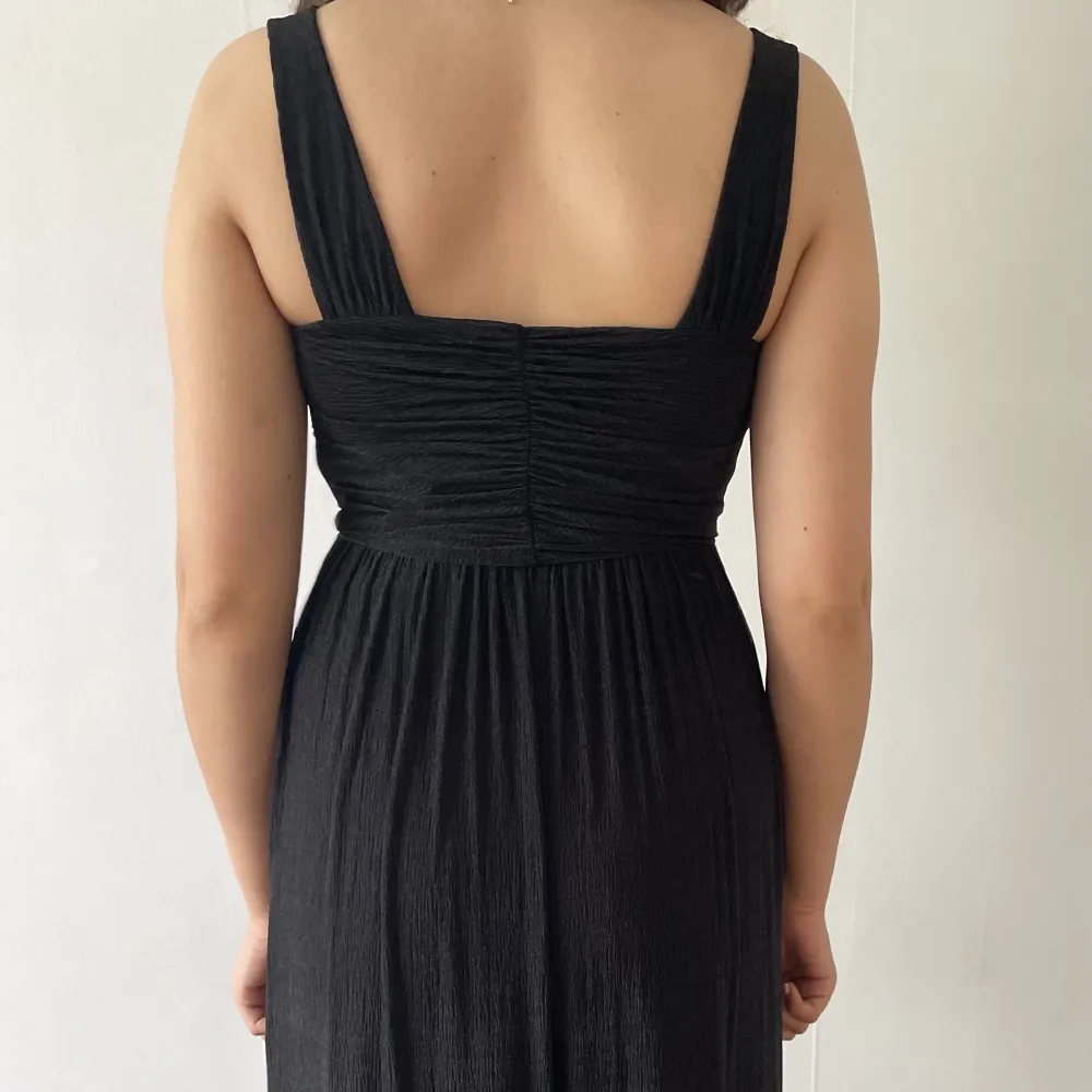 Lång svartklänning som har en enkel design och passar både för en enklare och pampiga festligheter.  Klänningen är aldrig använd och säljs pga platsbrist. Klänningar.