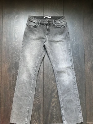 Jeans från NA-KD - Helt oanvända jeans i grå tvätt från Moa Mattsons kollektion för NA-KD. Normalhög midja och raka i benen med en liten slits vid foten :) Orginalpris är 600