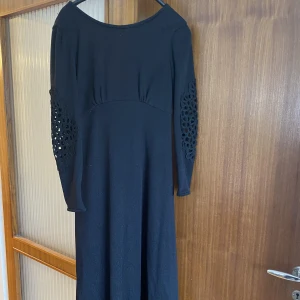 Klänning - Svart klänning med v-ringad rygg och detaljer