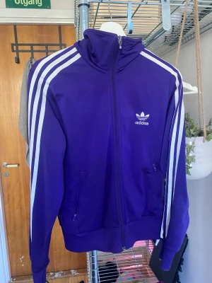 Adidas zipup - Säljer min jättecoola adidas zip💗 inte använd mer är 3 gånger och har inga defekter💖den ser blå ut på bilden men den är mer av en lila/blå färg!
