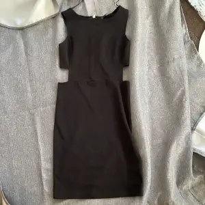 En svart klänning med dragkedja på baksidan och lite öppet på sidorna från bubbleroom:)