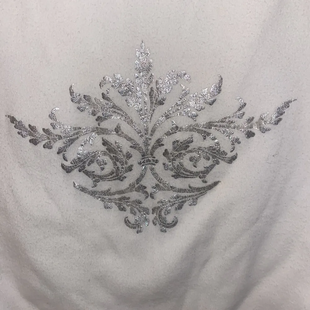 Långärmad vit tröja med vida ärmar och lite kroppad. Med vit silver detalj. Frakt ingår inte!💞. Toppar.