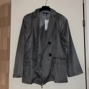 Kavaj - Ganska basic kavaj/blazer i en snygg grå färg. Normal i längd och passform passar storlek XS/S. Prislapp kvar!