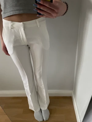 Kostymbyxor  - Säljer mina vita low waist kostymbyxor från bikbok med bootcut med slit längst ner i färgen vit i storlek 34💖 