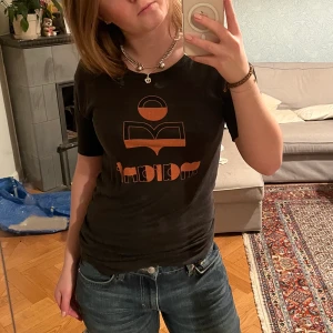 Isabel Marant t-shirt - Såå fin t-shirt från isabel marant. Tröjan har några få små hål vid armhålorna som kommit eftersom jag sprättat upp sömmen som höll ”uppvikningen” i ärmarna, därav det låga priset. På sista bilden kan man se hur ärmarna från början såg ut.
