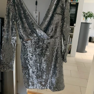 Silver klänning  - En paljett klänning i silver från NAKD. Säljer pga att den inte kommer till användning. Oanvänd