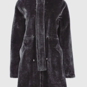 Grå parks i fuskpäls - Parka i grå fuskpäls. Dragsko i midjan och luva. Knappt använd. Storlek 38.