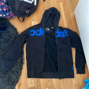 Svart adidas hoodie med blått tryck  - Fint skick på tröjan, med inga större problem. Storleken är S. Säljer då den inte passar längre 