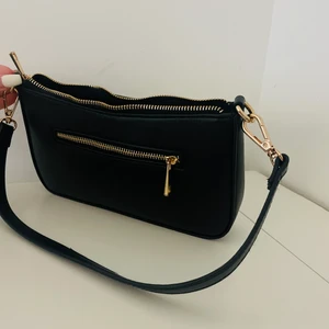 Axelremsväska med guld detaljer  - Denna väskan är använd ett par gånger. Eftersom att den bara ligger i garderoben har jag bestämt mig för o sälja den till någon som kmr ha mer användning av den. Har tagit väl hand om den så den är i god skick, hoppas ni är intresserade :) 