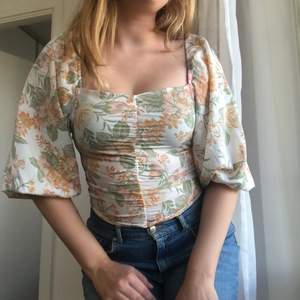 Fin blommig blus från Monki med puffärmar och kvadratisk halslinje. Den kan även bäras off-shoulder. Mycket bra skick. Säljer för 50kr då den inte kommer till användning och är snäppet för liten.