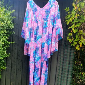 Fantastisk långklänning från 70-talet!  -  En långklänning från engelska kultmärket Mackerness! Underbart mönster i olika rosa, lila och blå nyanser. Stora vida fjärilsärmar. Övermaterialet är en skir polyester och klänningen har underklänning i syrenlila. Fint skick! 350 kr pp skicka lätt 66 kr