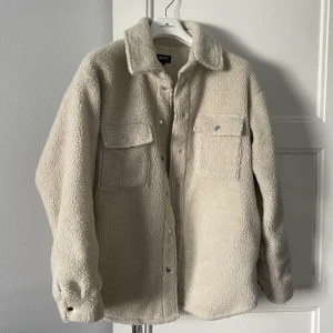 Oversized Teddy Kappa - Säljer min fina kappa/jacka då jag har en liknande som jag får mer användning av! Svårt att se på bilderna men den är i en beige/creme färg💕 Jag är 170cm och bär vanligtvis storlek 36 men denna blir perfekt oversized! Sparsamt använd och i ett superfint skick🥰 Vid snabb affär kan pris diskuteras🫶🫶