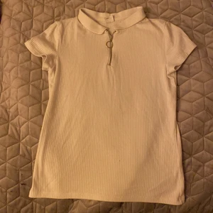 Vit tröja - Vit tröja med nån slags krage vid halsen och en dragkedja. Den har något slags randigt mönster. Använd några gånger