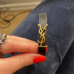 Ysl armband  - Säljer mitt ysl armband då jag fick ett med silver berlock i julklapp och använder silver mer. Lite slitningar på metallen se på bild 2, men det är inget man märker 