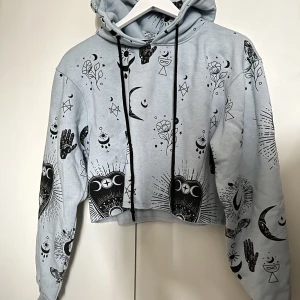 Missguided Hoodie - Ljusblå cropped hoodie från Missguided med celestial tryck. Loose fit. Använd en gång. 