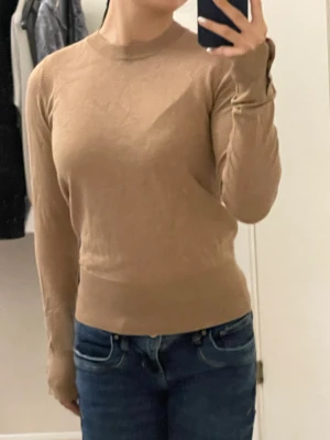 Beige tröja - Säljer en fin stickad beige/brun tröja med knappar på armarna. Använd få gånger.