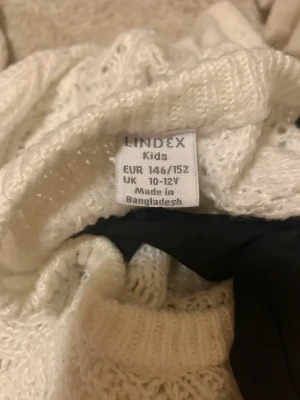 Tröja - Stickad tröja från Lindex rosett i ryggen andvänd 1-3 gånger. Tvättas innan köp.