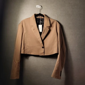 Kathy kavaj från Filippa K. - Kathy kavaj från Filippa K i biege/bryn färg och storlek S. Aldrig använd och därmed i nyskick.