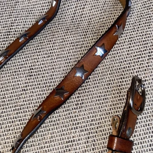 Trendigt bälte skärp med silvriga stjärnor äkta läder / skinn - Brunt trendigt bälte skärp med silvriga stjärnor studs på. 105 cm långt och har flera användas till flera storlekar. Äkta läder / skinn. Från Italien. Märke: depeche. Kostade 999 kr. Skitsnyggt på! 