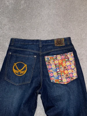 Baggy jeans  - Skit baggy mörk blå jeans med broderade / mönstrade backfickor. Size 36/32. Bra condition. TAR BUD