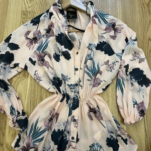 Rosa topp - Somrig topp med blommor detaljer. Passal L/Xl, ny och oanvänd. Säljer pga det inte passar. Krammar magen och ger en hourglass form