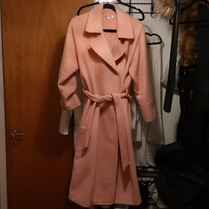 Rosa ullkappa stl 44 - Jättefin kappa i jättefint skick. Färgen är mer åt ljusrosa hållet.  Kan skicka mer bilder vid intresse.