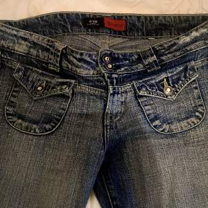 Bootcut lågmidjade jeans med fina detaljer och en ”washed out” denim färg. Köpta och använda en eller två gånger men säljer pågrund av att den ej är min storlek. Byxorna är i bra skick. Pris kan diskuteras.  Midjemått: 44,5 Innerbenslängd: 78