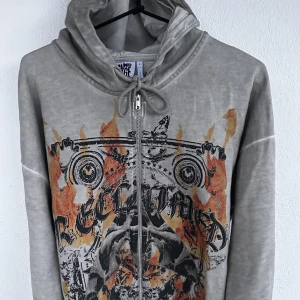 Gräddvit huvtröja med flammönster - I nyskick, endast testad.  För dig som vill ha ett unikt plagg med personlig stil. Huvtröjan har fickor på bägge sidor och matrialet på insidan är mjukt och behagligt.