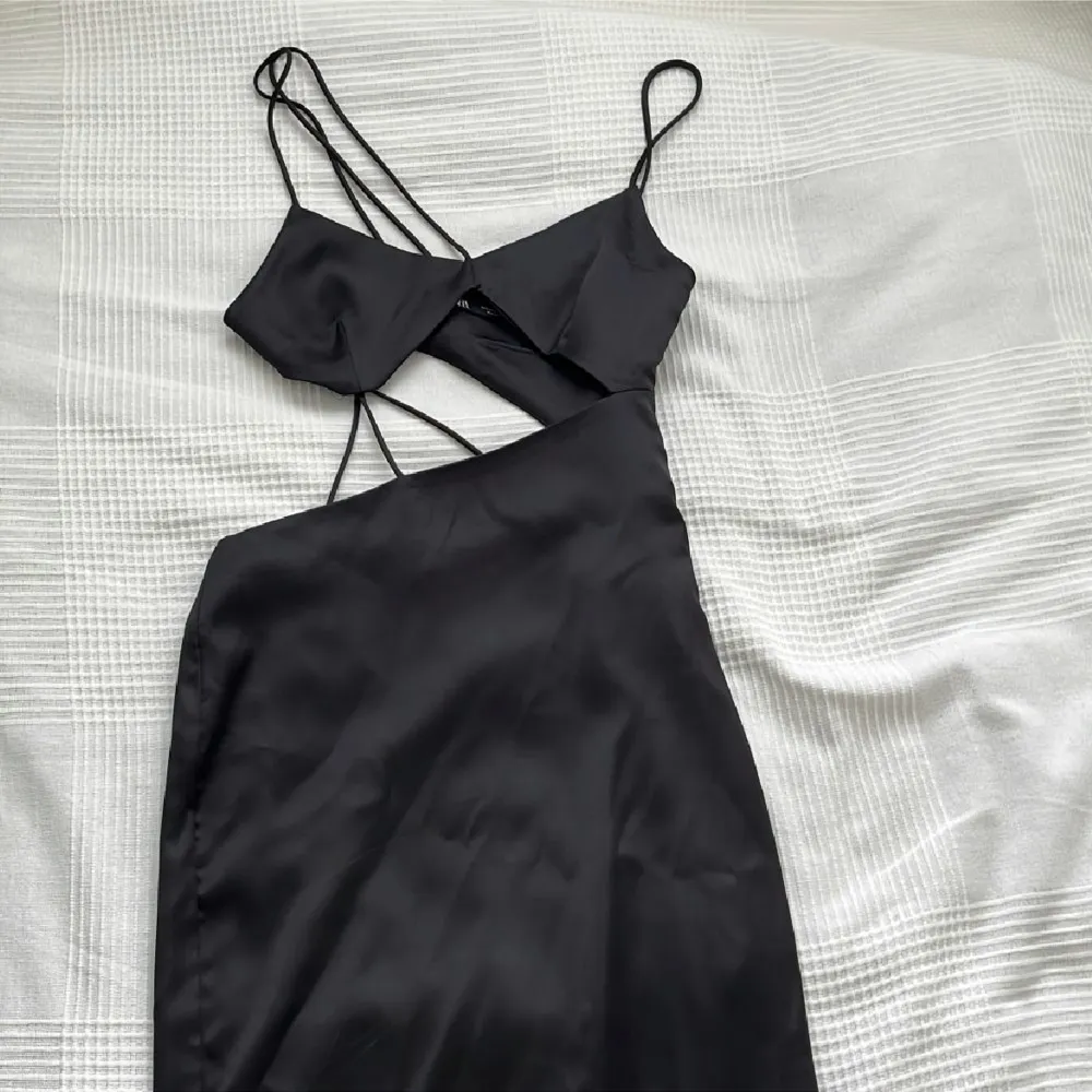 Snygg svart klänning från zara lite längre i modellen och med cut outs. Passar till långa olika festliga tillfällen, finns ej att köpa längre! Använd en gång!. Klänningar.