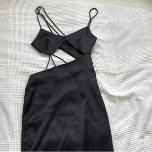 Snygg svart klänning från zara lite längre i modellen och med cut outs. Passar till långa olika festliga tillfällen, finns ej att köpa längre! Använd en gång!