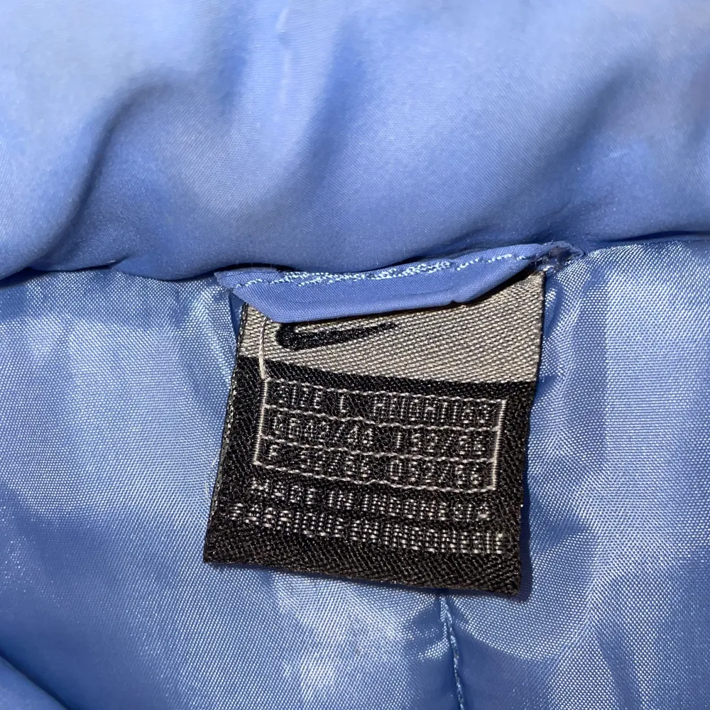 Blå pufferjacka från Nike med retrokänsla. Fint skick. Står i jackan att den är strl L men passar mig som vanligtvis bär strl XS-S utan att vara oversized, alltså är den liten i storleken. Fraktkostnad kan komma att ändras. Hör av dig vid frågor😊. Jackor.