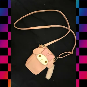 My Melody väska - en ungefär 15 cm lång väska med sanrio karaktären "My Melody" på. justerbara remmar. den har aldrig använts och kommer med den fluffiga nyckelringen :3
