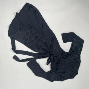 Glansig omlottklänning - Väldigt fin svartgrå omlottklänning i silkesliknande tyg! Från J lindeberg