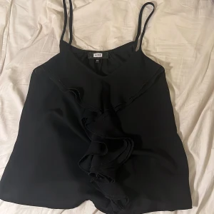 Svart topp - Super gullig svart topp från Bikbok  i storlek xs!🤍med lite volangdeltaljer.