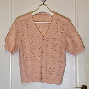 Rosa stickad tröja - Rosa stickad tröja med kortare ärmar. Sitter fint på och är sparsamt använd.